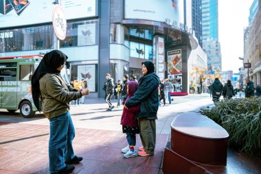 Şangay, Çin - 8 Aralık 2024 Malezya tesettür ailesi Nanjing Yolu 'nda turist olarak fotoğraf çekiyor