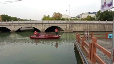 Şangay, Çin, 7 Aralık 2024: Zhujiajiao antik kentinde bir tekneyle nehri temizleyen işçiler.