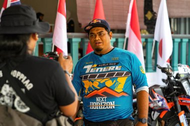 Pahang, Malezya - 24 Eylül 2022 Bir motosiklet sürücüsünün portresi hobisi için medya tarafından röportaj veriliyor.