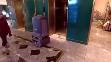 Şangay, Çin - 7 Aralık 2024: Lobiden Mercure Hotel 'e gıda dağıtım robotu giriyor.