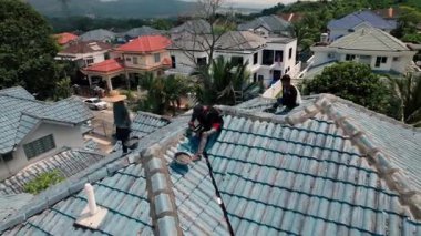 Bangi, Malezya - 16 Eylül 2023: Bungalovdaki tamircilerle eski çatı manzarasını yükseltmek