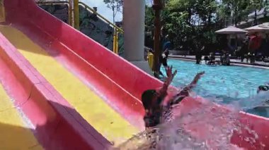 Sepang, Malezya - 31 Temmuz 2025 Mutlu çocuklar Splash Mania su parkına kayıyor