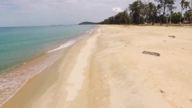 Terengganu 'daki sakin turkuaz suyun yanında uzanan boş kumlu sahil.