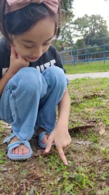 Küçük kız Mimosa Pudica ya da Hassas Bitki, Dokunma-Bana, Utanç-Bitkisi, Yaşa-ve-Diya, Mütevazi Bitki. Dikey