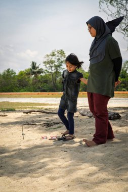 Güneşli bir günde kumsalda iki kardeş..
