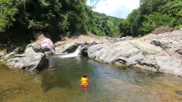 Дитина Рятувальній Куртці Плаває Гірській Річці Водоспадом Сонячний День Високоякісні — стокове відео