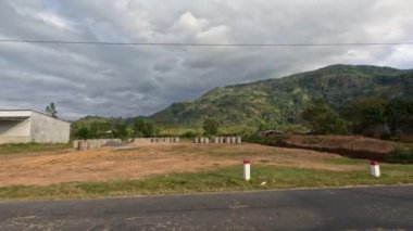 Vietnam 'daki kırsal yol, dağ bölgesi. Motosiklet geçiyor, bayrak sallanıyor. Yüksek kalite 4k görüntü