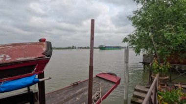 Mekong deltasında bir kargo gemisi. Önde küçük bir yolcu gemisi var. Vinh Long vilayeti, Vietnam. Yolcu hizmeti. Yüksek kalite 4k görüntü
