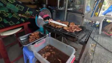 Barbekü Vietnamlı sokak yemekleri marine edilmiş et suon. Kadın eli takla atıyor. Yüksek kalite 4k görüntü