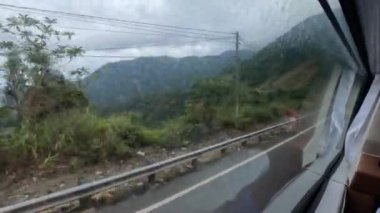 Yataklı otobüste bir yolcu, televizyonu olan üst ranzada. Bacaklar. Pencereden sokak manzarası. Futa otobüsü, Vietnam. Yüksek kalite 4k görüntü