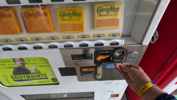 Pov Hand Ukraine Bracelet Puts Coins Japanese Vending Machine Buys — стоковое видео