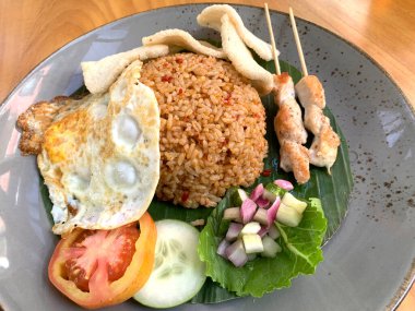 Dünyanın en iyi yemeklerinden biri Endonezya 'nın ünlü haber kanalı Kızarmış Pirinç Nasi Goreng tarafından sunulan kızarmış yumurta, tavuk satay ve kerupuk veya kraker ve turşu salatası ile servis edilir.
