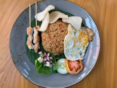 Dünyanın en iyi yemeklerinden biri Endonezya 'nın ünlü haber kanalı Kızarmış Pirinç Nasi Goreng tarafından sunulan kızarmış yumurta, tavuk satay ve kerupuk veya kraker ve turşu salatası ile servis edilir.