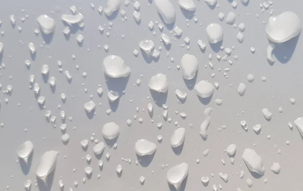 マルチメディアコンテンツの背景に適した白い色面を通した水滴の視点 — ストック写真
