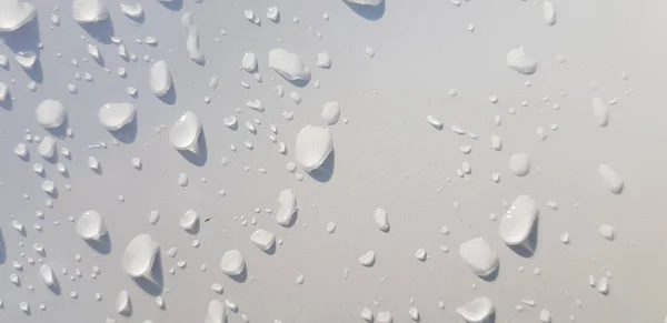 マルチメディアコンテンツの背景に適した白い色面を通した水滴の視点 — ストック写真