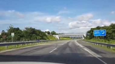 Otoyol boyunca ya da paralı yol altyapısında mavi gökyüzü ve beyaz bulutlu POV görüntüsü ile güzel boş yol videosundan geçen bir kameradan çekiliyor.