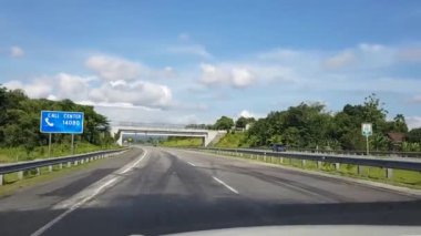 Otoyol boyunca ya da paralı yol altyapısında mavi gökyüzü ve beyaz bulutlu POV görüntüsü ile güzel boş yol videosundan geçen bir kameradan çekiliyor.