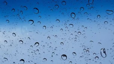 Su damlacıkları cam yüzey üzerinden mavi gökyüzüne karşı perspektif ile multimedya içeriği için iyidir