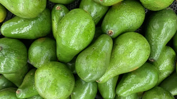 fresh produce of green avocados at the local market, healthy fresh fruit for salad or juice or guacamole