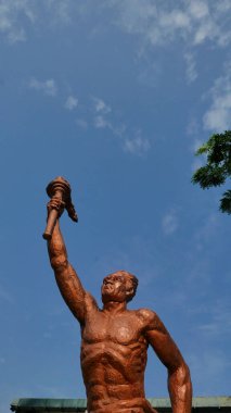 Surakarta, Endonezya, 20 Haziran 2023, spor ruhu heykeli mavi gökyüzüne karşı meşale tutan, Manahan Stadyumu Surakarta 'da bulunan Patung obor yöneticisi, spor ruhunun sembolü.