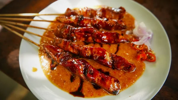 stock image Chicken satay or Indonesian sate ayam, grilled chicken satay with peanut and soy sauce completed with chili and onion, indonesian delicacy