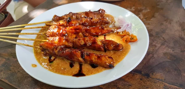 鶏のサテまたはインドネシアのサテ チリと玉ねぎで完成ピーナッツと醤油で鶏のサテを焼き インドネシアの珍味 — ストック写真