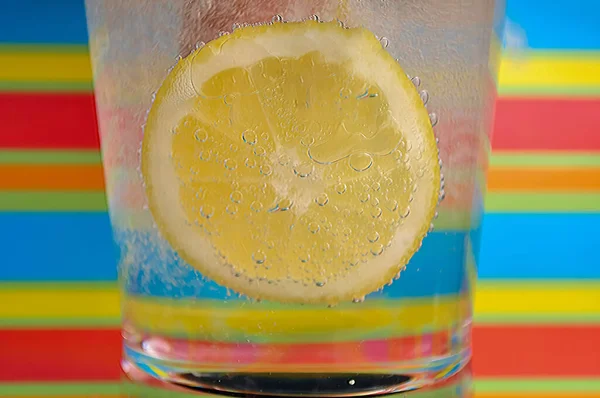 Lemonade fizzy drink in a clear glass with colorful background showing fizzy bubbles good for your multimedia content creation background
