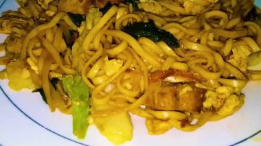 Mie goreng Jawa, geleneksel java usulü kızarmış erişte tatlı ve lezzetli Endonezya usulü kızarmış erişte, bakmi goreng, bakmi goreng jawa beyaz tabakta servis edilir.