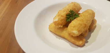 Ana menüden önce bir restoranda aperatif ya da atıştırmalık olarak servis edilen beyaz tabağa konmuş kızarmış mozzarella peyniri çubukları.