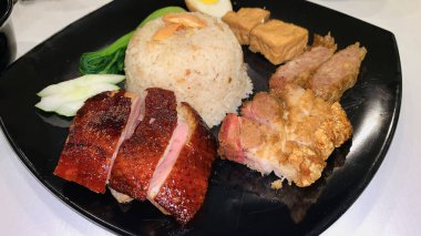 Süper lezzetli kızarmış pekin ördeği Hainan pilavı ve kızarmış domuz göbeği ile servis edilir. Prestijli doğu yemeği restoranında lezzetli Çin yemeği.