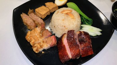 Süper lezzetli kızarmış pekin ördeği Hainan pilavı ve kızarmış domuz göbeği ile servis edilir. Prestijli doğu yemeği restoranında lezzetli Çin yemeği.