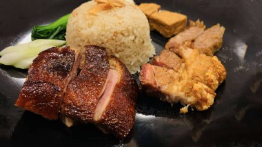 Süper lezzetli kızarmış pekin ördeği Hainan pilavı ve kızarmış domuz göbeği ile servis edilir. Prestijli doğu yemeği restoranında lezzetli Çin yemeği.