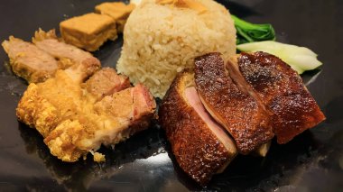 Süper lezzetli kızarmış pekin ördeği Hainan pilavı ve kızarmış domuz göbeği ile servis edilir. Prestijli doğu yemeği restoranında lezzetli Çin yemeği.