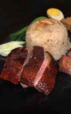 Süper lezzetli kızarmış pekin ördeği Hainan pilavı ve kızarmış domuz göbeği ile servis edilir. Prestijli doğu yemeği restoranında lezzetli Çin yemeği.