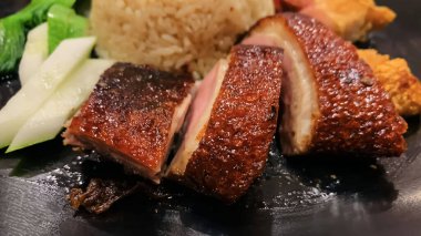 Süper lezzetli kızarmış pekin ördeği Hainan pilavı ve kızarmış domuz göbeği ile servis edilir. Prestijli doğu yemeği restoranında lezzetli Çin yemeği.