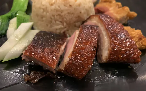 Süper lezzetli kızarmış pekin ördeği Hainan pilavı ve kızarmış domuz göbeği ile servis edilir. Prestijli doğu yemeği restoranında lezzetli Çin yemeği.