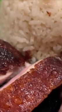 Süper lezzetli kızarmış pekin ördeği Hainan pilavı ve kızarmış domuz göbeği ile servis edilir. Prestijli doğu yemeği restoranında lezzetli Çin yemeği.