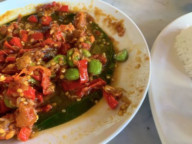 Sambal Pete (Petai) ya da acı fasulye ile acı biber sosu, parkia speciosa, popüler bir Endonezya yemeği. Bali 'de bir restoranda lezzetli yemekler.