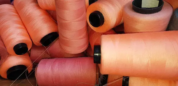 Group of colorful yarn on spool, yarn on tube, cotton, wool, linen thread orange colorful used in fashion