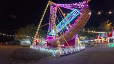 Aydınlatılmış korsan gemisi eğlence parkında salıncak gezisi, Noel pazarı