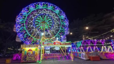 Geceleyin Funfair dönme dolabını aydınlatır, gece vakti lunaparkta dönme dolabı hareket ettirirdi.