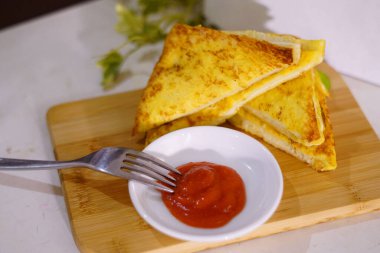 Taze kızarmış yumurtalı ekmek ve beyaz tabakla doldurulmuş peynirli tost. Restoranda yeni kızartılmış.