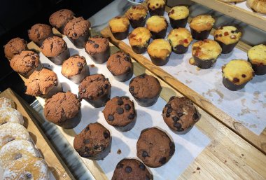 Lines of delicious chocolate and vanilla muffins Freshly baked homemade chocolate chip muffins Out of the oven muffins in muffin cups