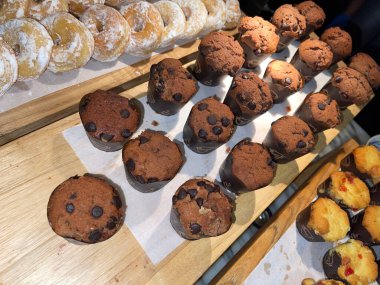Lines of delicious chocolate and vanilla muffins Freshly baked homemade chocolate chip muffins Out of the oven muffins in muffin cups