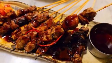 Baharat ve tatlı soya sosuyla marine edilmiş ev yapımı sığır eti, kişniş bifteği satay, soğan, biber, soya sosu ve domates ile servis edilen tabakta. Endonezya geleneksel yemek seti maranggi
