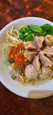 Bakso, indonesian meatball style served with beef broth soup and noodle springkled with fried onion and spring onion coupled with chili sauce on the top, very famous Asian street food clipart