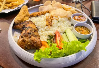 Nasi uduk ayam bakar, ya da hindistan cevizi sütü aromalı pirinç ızgara tavuk, taze salata ve biber ezmesi geleneksel Endonezya yemeği, Endonezya sokak yemeği, ev yapımı yemek