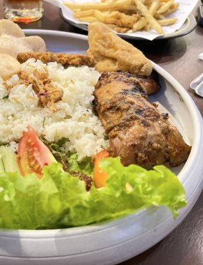 Nasi uduk ayam bakar, ya da hindistan cevizi sütü aromalı pirinç ızgara tavuk, taze salata ve biber ezmesi geleneksel Endonezya yemeği, Endonezya sokak yemeği, ev yapımı yemek