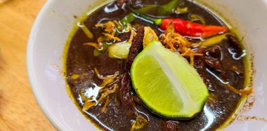Rawon ya da Endonezya siyah et çorbası, siyah renk Endonezya fındığı Kluwek 'ten. Limon, biber ezmesi, tuzlu yumurta ve krakerle servis edilir. Yemek tarifi, makale veya herhangi bir yemek içeriği veya blog için mükemmel