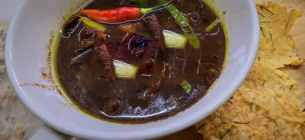 Rawon ya da Endonezya siyah et çorbası, siyah renk Endonezya fındığı Kluwek 'ten. Limon, biber ezmesi, tuzlu yumurta ve krakerle servis edilir. Yemek tarifi, makale veya herhangi bir yemek içeriği veya blog için mükemmel